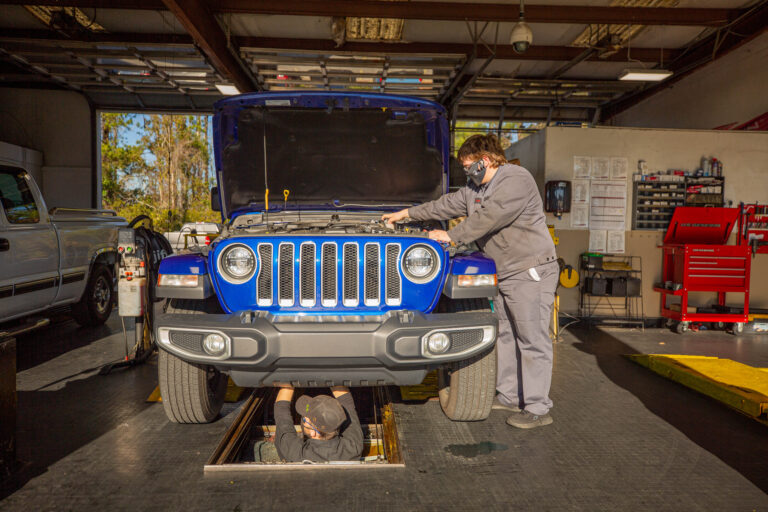 mechanic working on blue jeep