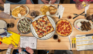 A cozy restaurant scene at Pies & Pints in Fayetteville, WV, featuring rustic decor, patrons enjoying gourmet pizzas and craft beers