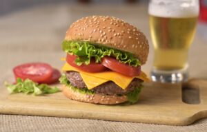 Juicy Burger Patty with Cheese, Tomato, and Lettuce. An Ice Cold Beer on Tap.