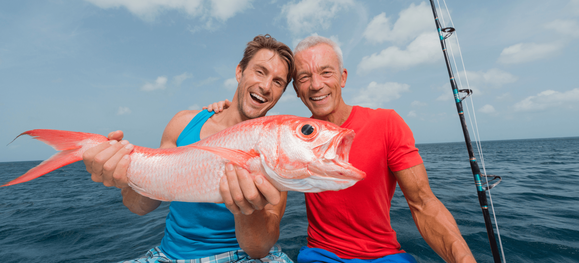 An older father and son on a fishing charter with their prized catch.