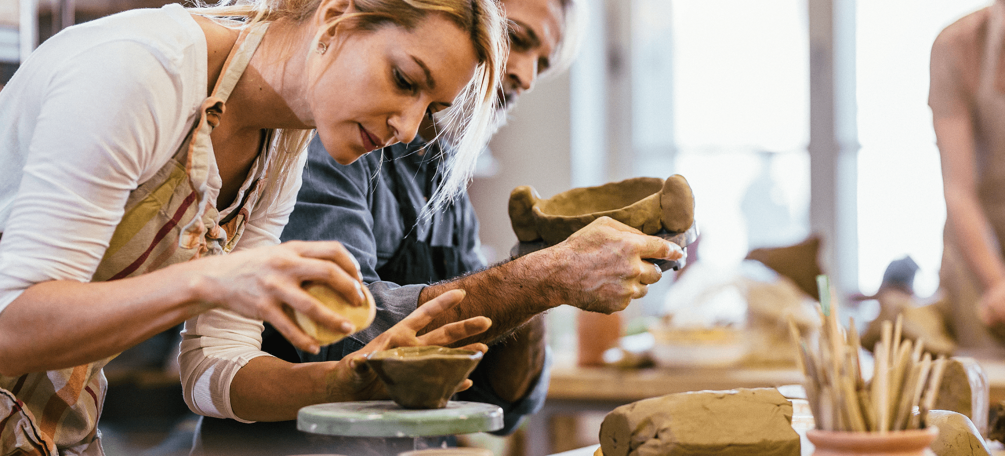 Man and woman in a pottery workshop making pottery.