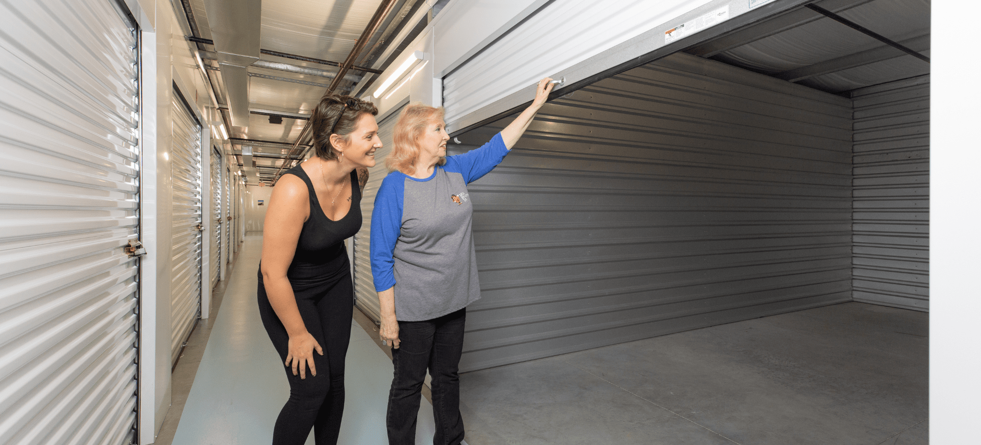 two ladies looking inside an empty storage unit of Mr. Store It in Myrtle Beach South Carolina