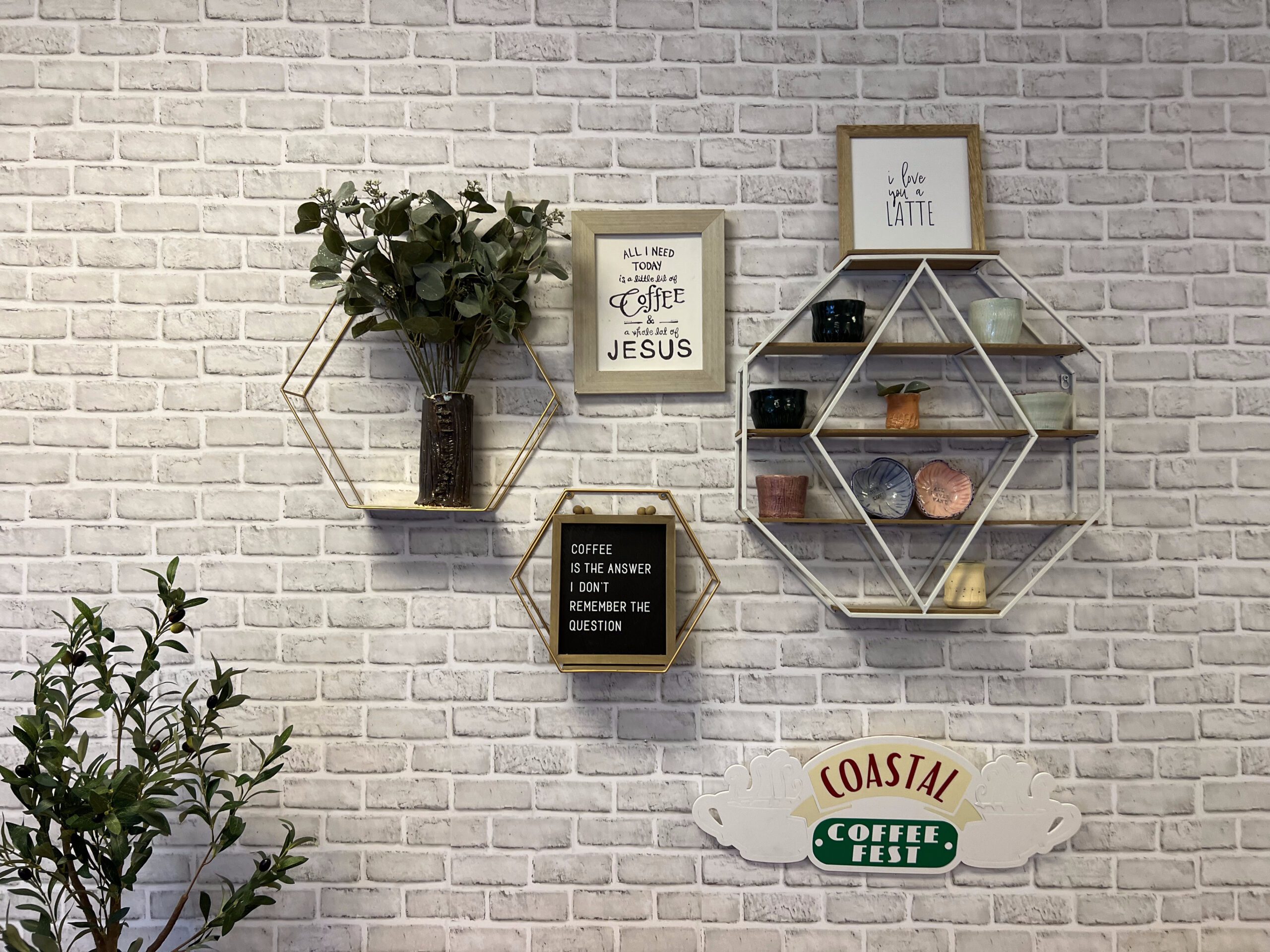 coffee decorations on a wall as well as a plant in the corner