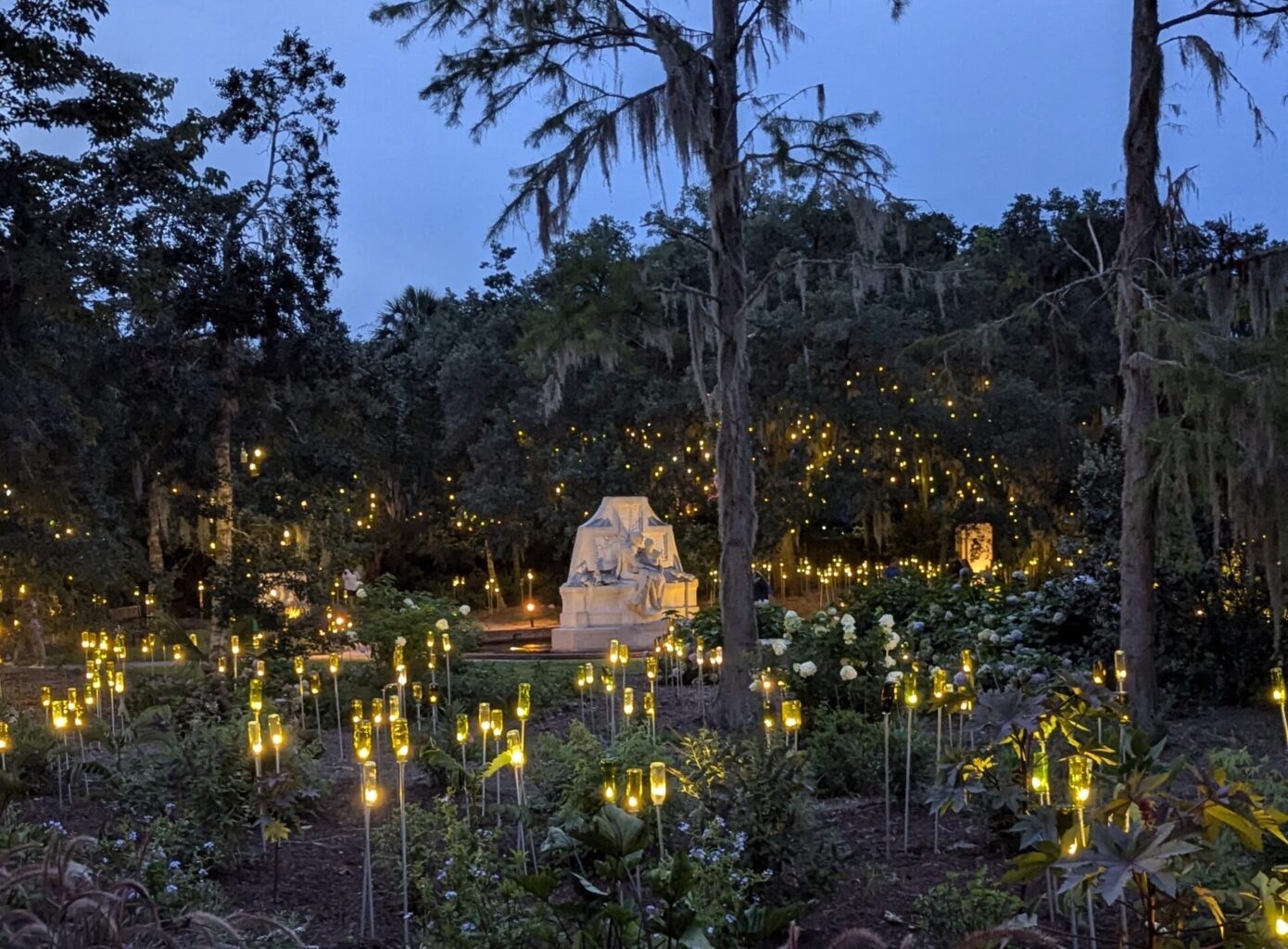Brookgreen Gardens in Myrtle Beach featuring lights in a garden with a statue and flowers around it