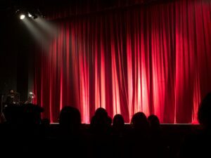 red curtain and people waiting on a show.